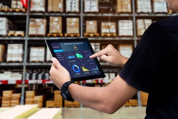 Person using tablet with warehouse management dashboard and analytics